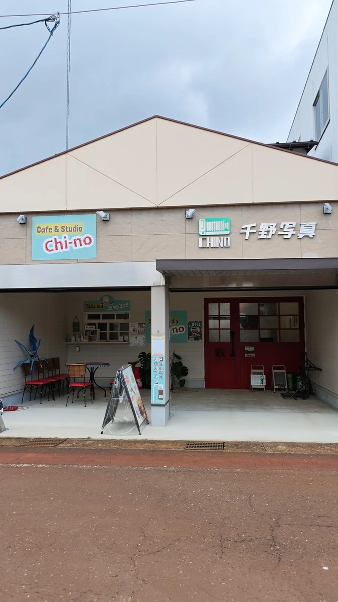 (左)建物の正面。左半分が屋根のあるテラス/(右)赤い両開きの扉