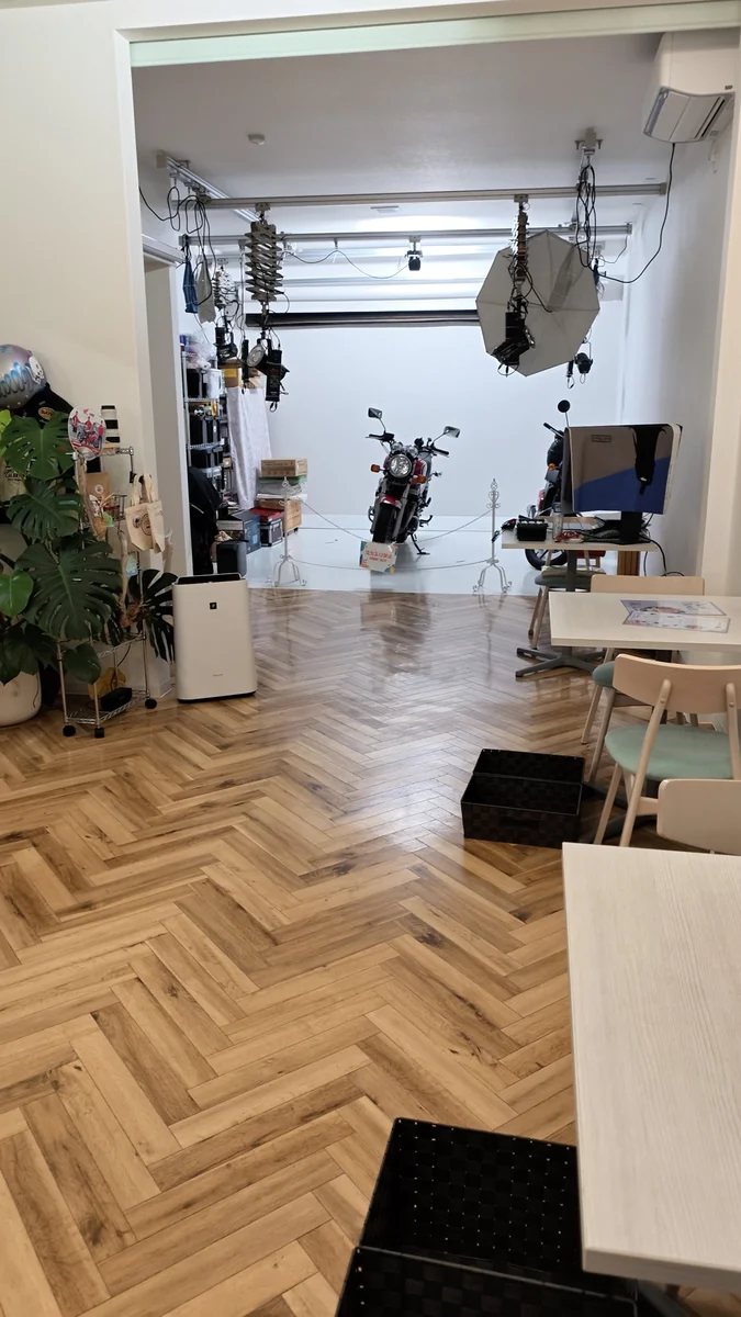 (左)カフェの席から見たスタジオ/(右)白いホリゾントに乗り入れたバイク