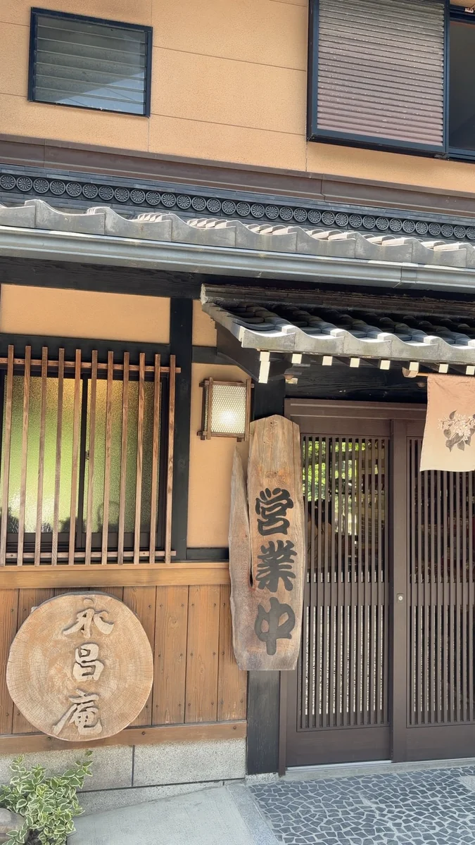 入口。「お食事処」の板と、丸太を切った「永昌庵」の看板、「営業中」の札