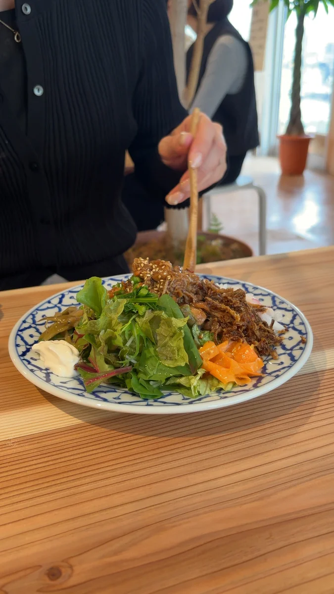 チキンルーローのワンプレート。ごはん、鶏の煮込み、生野菜、副菜が1枚のお皿に盛られています（左）／別の角度から（右）