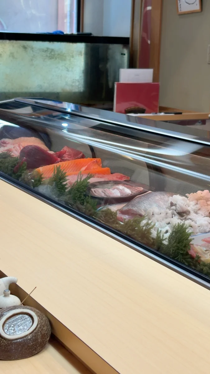 （左）カウンター席。正面がネタケースで、その奥が厨房です／（右）ケースの中。ここから、その日のお造りが出てきます
